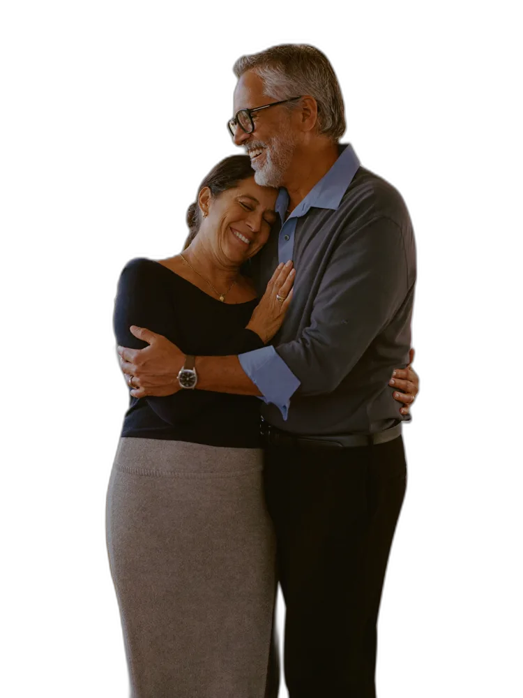 A relaxed, happy retired couple embracing at home, at ease about their future